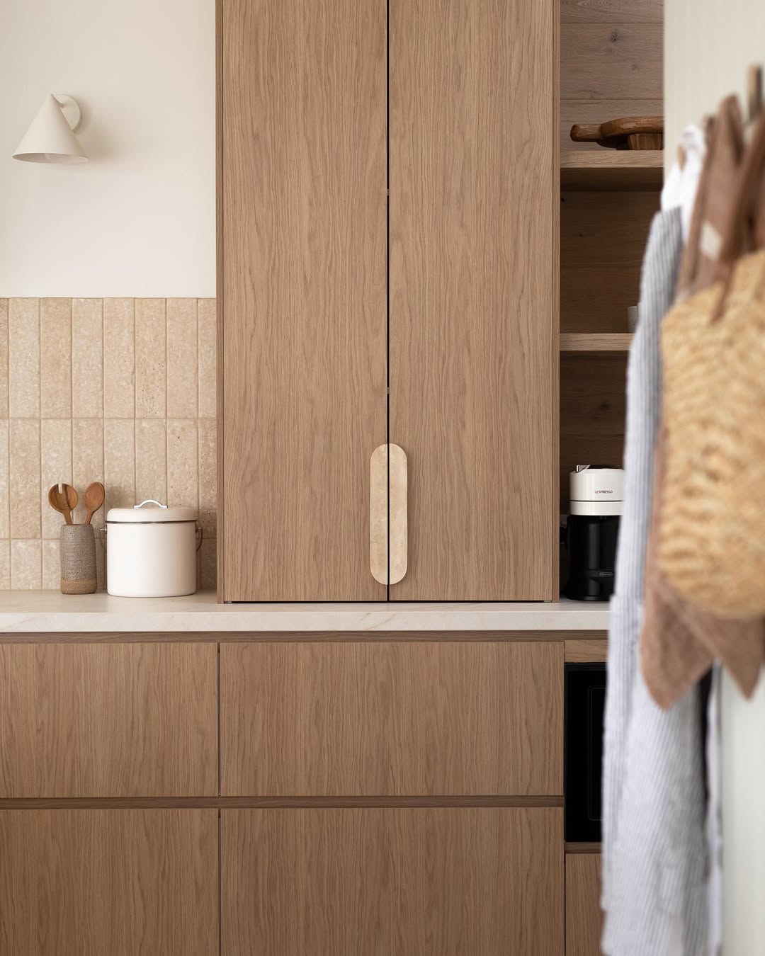 Manor Series hardware in travertine on oak shaker style cabinet doors