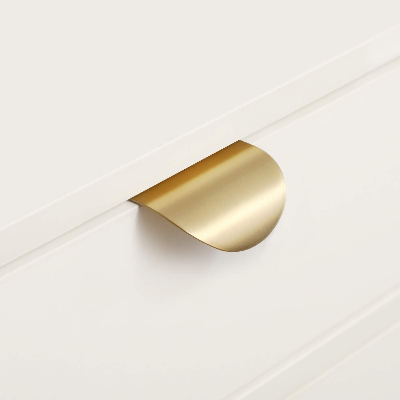 Gold metallic handle on a white surface
